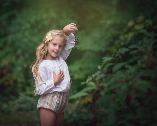 Girl picking berries at wood's edge